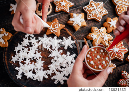 Friends decorating christmas gingerbread cookies 58021885