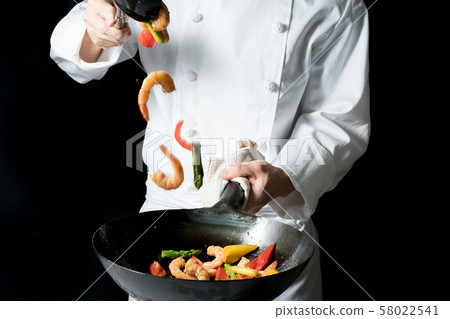 Cook shaking a wok Cook shaking a wok 58022541