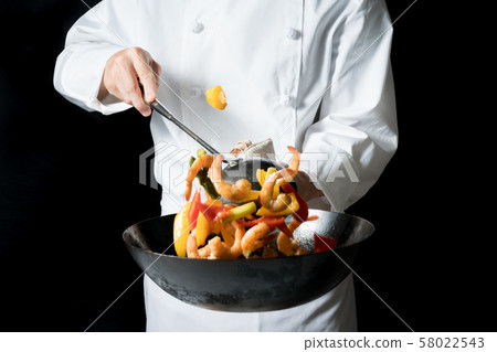 Cook shaking a wok Cook shaking a wok 58022543