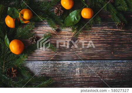 Christmas background with tangerines, fir branches and cones. Decorative winter frame 58027327