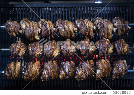 Twenty-one pork leg is grilled in a restaurant.  58028953