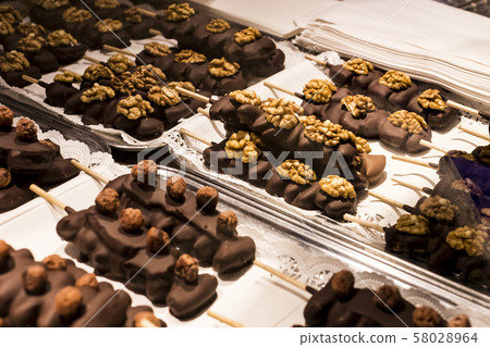 Fruits bananas, strawberries, nuts, apples, peaches drenched in white and dark chocolate.  Fruits bananas, strawberries, nuts, apples, peaches drenched in white and dark chocolate.  58028964