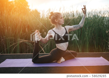 Girl practice yoga early morning on pier 58029285