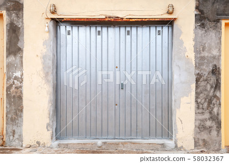 Shiny metal gate in grungy stone wall, texture 58032367