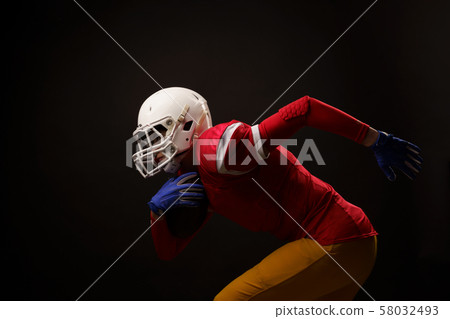 Image of side of running woman American soccer player in studio 58032493