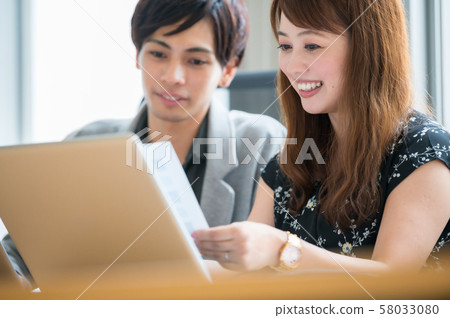 Young man and woman doing business desk work Young man and woman doing business desk work 58033080