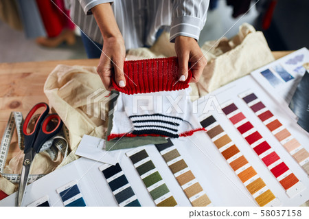 dressmaker making decision what color of textile to use to make clothes 58037158