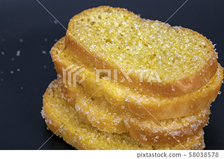 Delicious crisp sliced butter toast on black plate Delicious crisp sliced butter toast on black plate 58038578