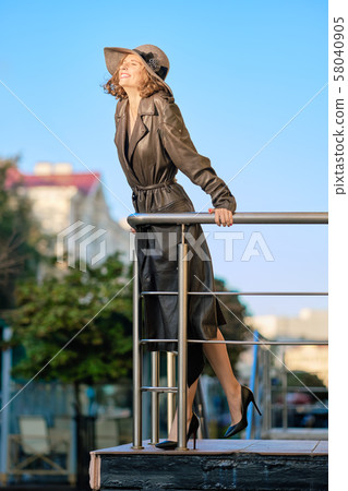 Beautiful lady in long vintage coat ant hat 58040905