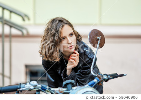 Pretty lady in leather coat and wild curly hair 58040906