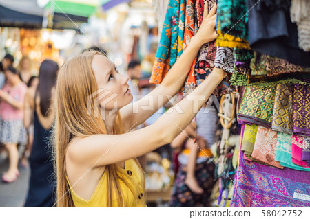 Woman traveler choose souvenirs in the market at Ubud in Bali, Indonesia Woman traveler choose souvenirs in the market at Ubud in Bali, Indonesia 58042752