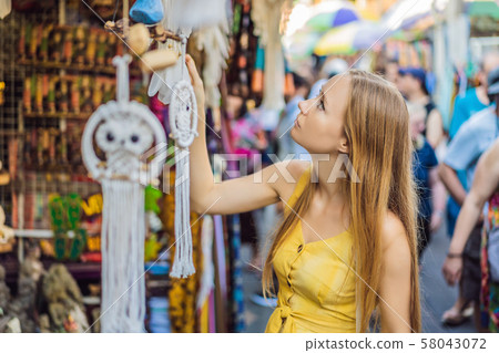 Woman traveler choose souvenirs in the market at Ubud in Bali, Indonesia Woman traveler choose souvenirs in the market at Ubud in Bali, Indonesia 58043072
