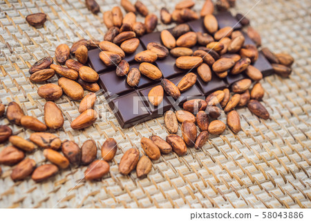 Chocolate and cocoa beans on a straw background Chocolate and cocoa beans on a straw background 58043886