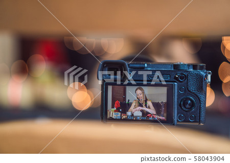 Female video blogger records video about Christmas gifts Female video blogger records video about Christmas gifts 58043904