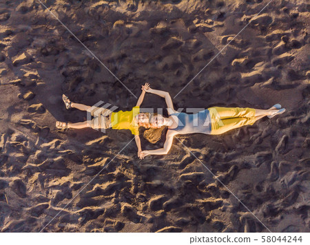 Mom and son are lying on the sand at sunset. View from the drone. Paradise, travel, vacation concept 58044244