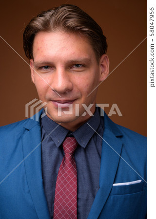 Studio shot of businessman against brown background Studio shot of businessman against brown background 58047956