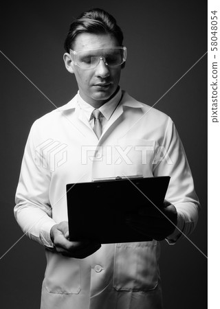 Man doctor wearing protective glasses shot in black and white Man doctor wearing protective glasses shot in black and white 58048054