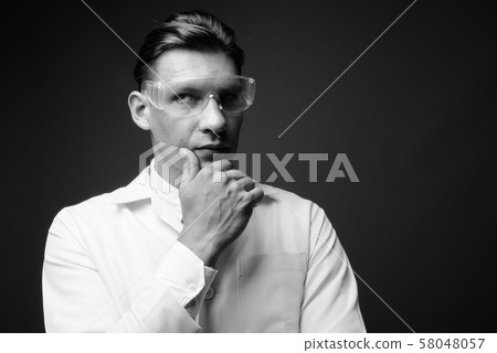 Man doctor wearing protective glasses shot in black and white Man doctor wearing protective glasses shot in black and white 58048057