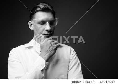 Man doctor wearing protective glasses shot in black and white Man doctor wearing protective glasses shot in black and white 58048058