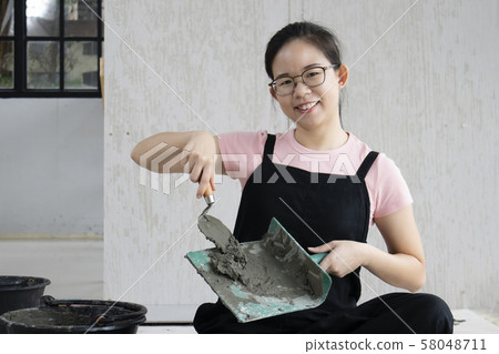 Home renovation and improvement concept. Young Asian Woman happy and preparing tile work 58048711