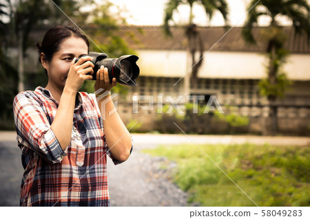 Woman photographer is taking images with dslr camera Woman photographer is taking images with dslr camera 58049283