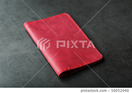 Red leather cover for a passport on a dark Red leather cover for a passport on a dark 58052048