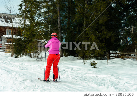 A woman is skiing and climbing up the hill to go A woman is skiing and climbing up the hill to go 58055106