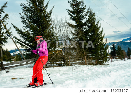 A woman is skiing and climbing up the hill to go A woman is skiing and climbing up the hill to go 58055107