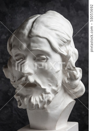 Gypsum copy of ancient statue John the Baptist head on dark textured background. Plaster sculpture Gypsum copy of ancient statue John the Baptist head on dark textured background. Plaster sculpture 58055692