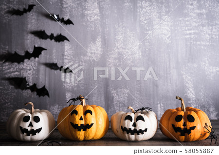 Orange ghost pumpkins with witch hat on gray wooden board background 58055887