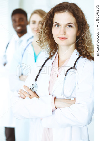 Happy doctor woman with medical staff at the hospital. Multi ethnic people group 58056235