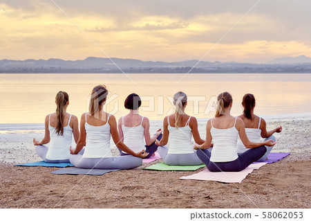 Women meditating outdoors Women meditating outdoors 58062053