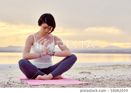 Woman meditating outdoors Woman meditating outdoors 58062054