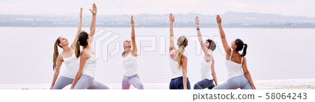 Women practicing yoga outdoors 58064243
