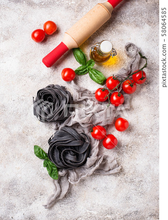 Black uncooked pasta with tomato and basil Black uncooked pasta with tomato and basil 58064585