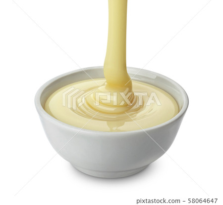 Pouring condensed milk isolated on white background Pouring condensed milk isolated on white background 58064647
