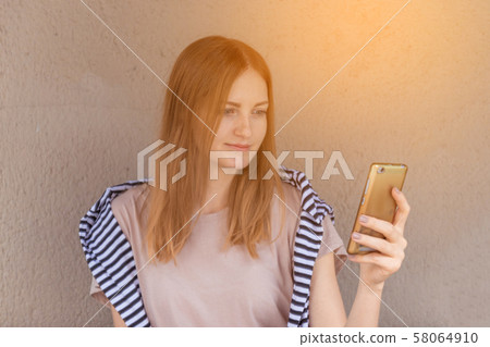 Caucasian female watching her photos on cell telephone while relaxing in cafe during free time Caucasian female watching her photos on cell telephone while relaxing in cafe during free time 58064910