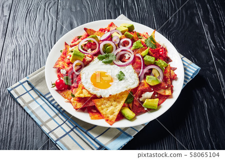 Fried tortilla chips cooked with eggs, ham Fried tortilla chips cooked with eggs, ham 58065104
