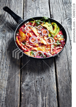 chilaquiles with ham, cheese, avocado in a skillet chilaquiles with ham, cheese, avocado in a skillet 58065119