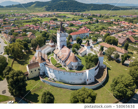 Aerial view of fortified church surrounded powerful thick walls in Transylvania overlooking the Aerial view of fortified church surrounded powerful thick walls in Transylvania overlooking the 58065638