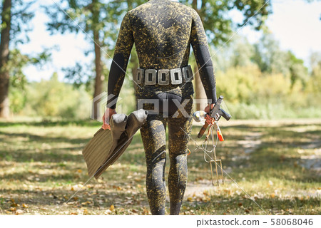 diver in wet suit and flippers with harpoon shotgun get ready for water hunting fishing 58068046