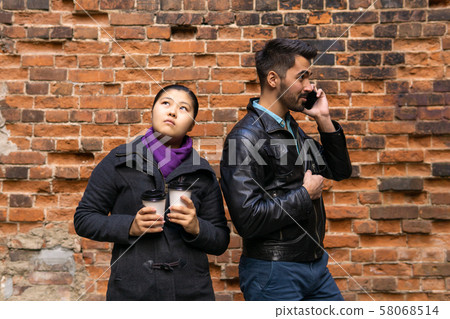 young man talking on the phone, girl misses with 58068514