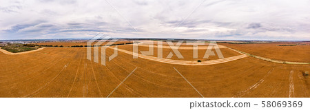 Aerial drone view of farmland. Combines work in the agricultural lands, harvesting. 180 degrees 58069369
