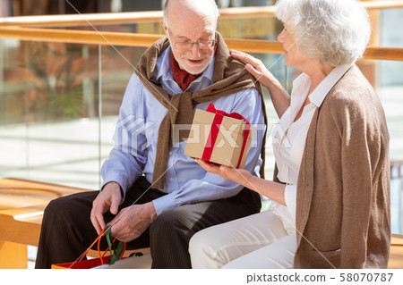 Senior couple with gift Senior couple with gift 58070787