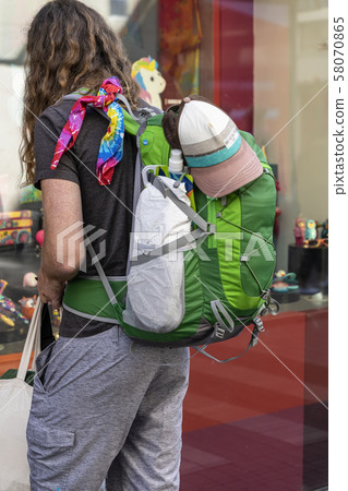 Unrecognizable tourist with a backpack standing near the showcase of shop souvenirs, travel and 58070865