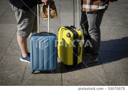 Unrecognizable two young men, travelers standing near a suitcases, summer sunny day, travel and Unrecognizable two young men, travelers standing near a suitcases, summer sunny day, travel and 58070870
