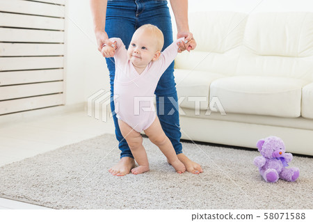little baby girl first steps with the help of mom little baby girl first steps with the help of mom 58071588