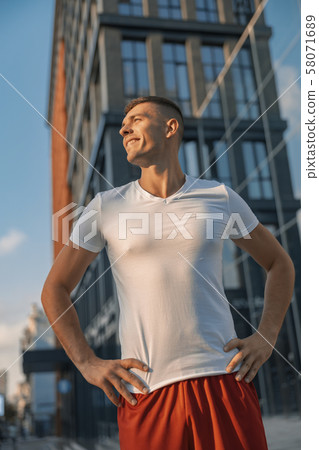 Joyous sportive attractive young man looking away 58071689