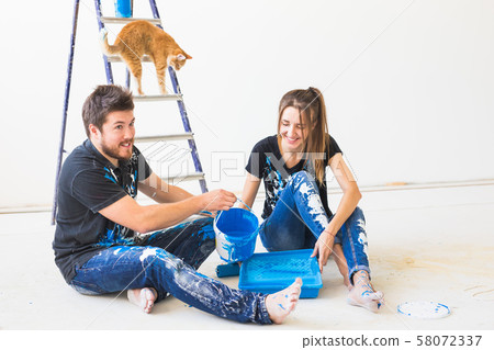 Repair, pet, renovation and people concept - couple with cat going to paint the wall, they are 58072337