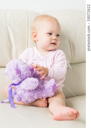 Children, infant and childhood concept - beautiful smiling baby sitting Children, infant and childhood concept - beautiful smiling baby sitting 58072622